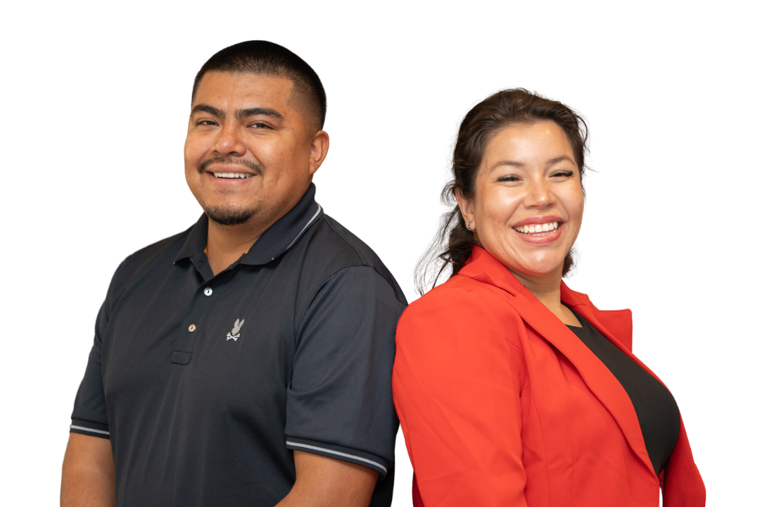 Smiling employees pose back to back in front of a white background
