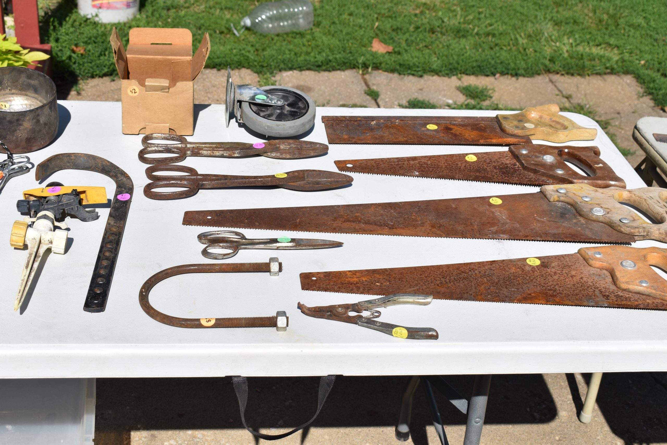 Table of antique saws put out for sale during an estate sale hosted by Grasons