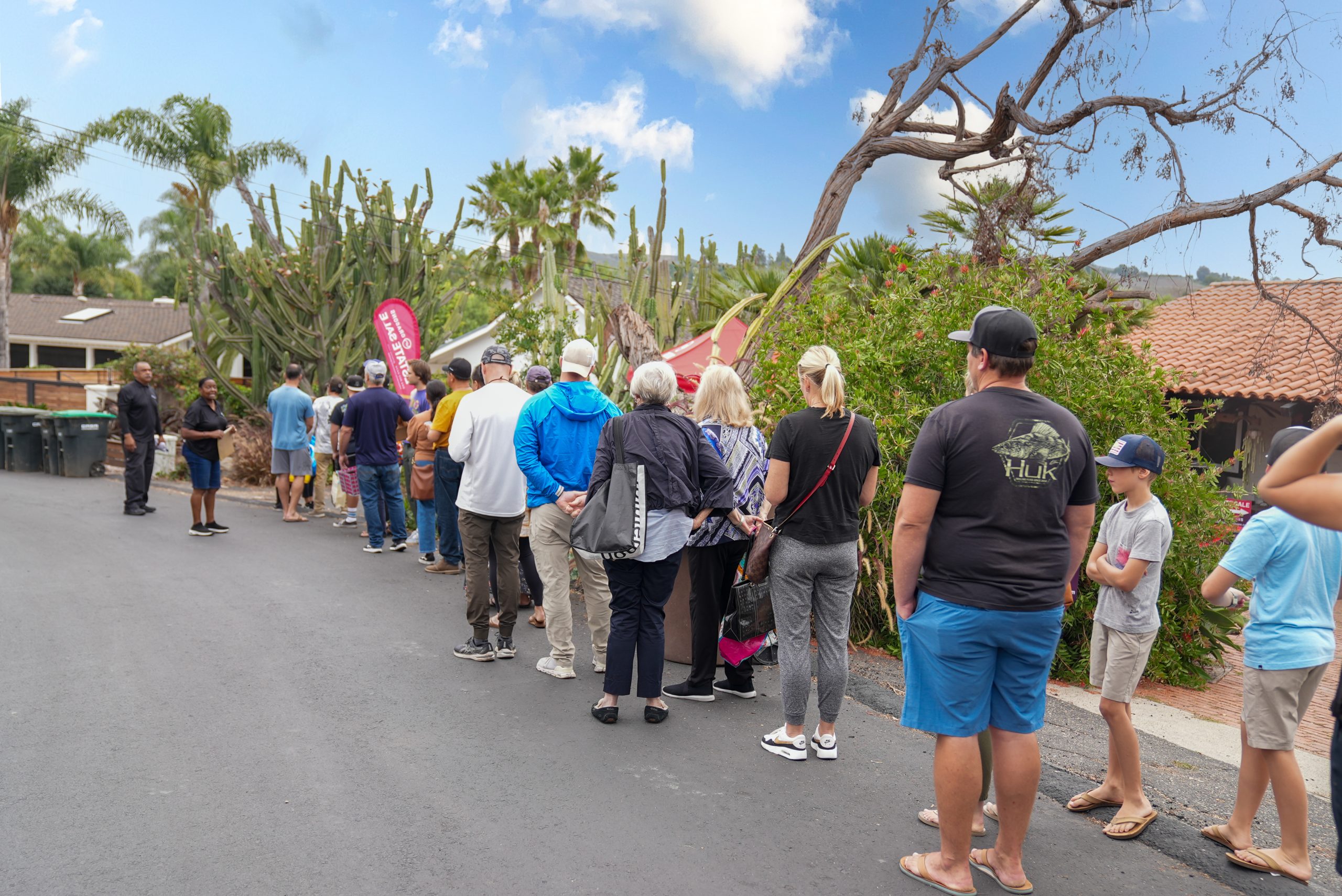 Several people wait in line for an estate sale.