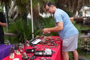 man looking at items at an estate sale from the side