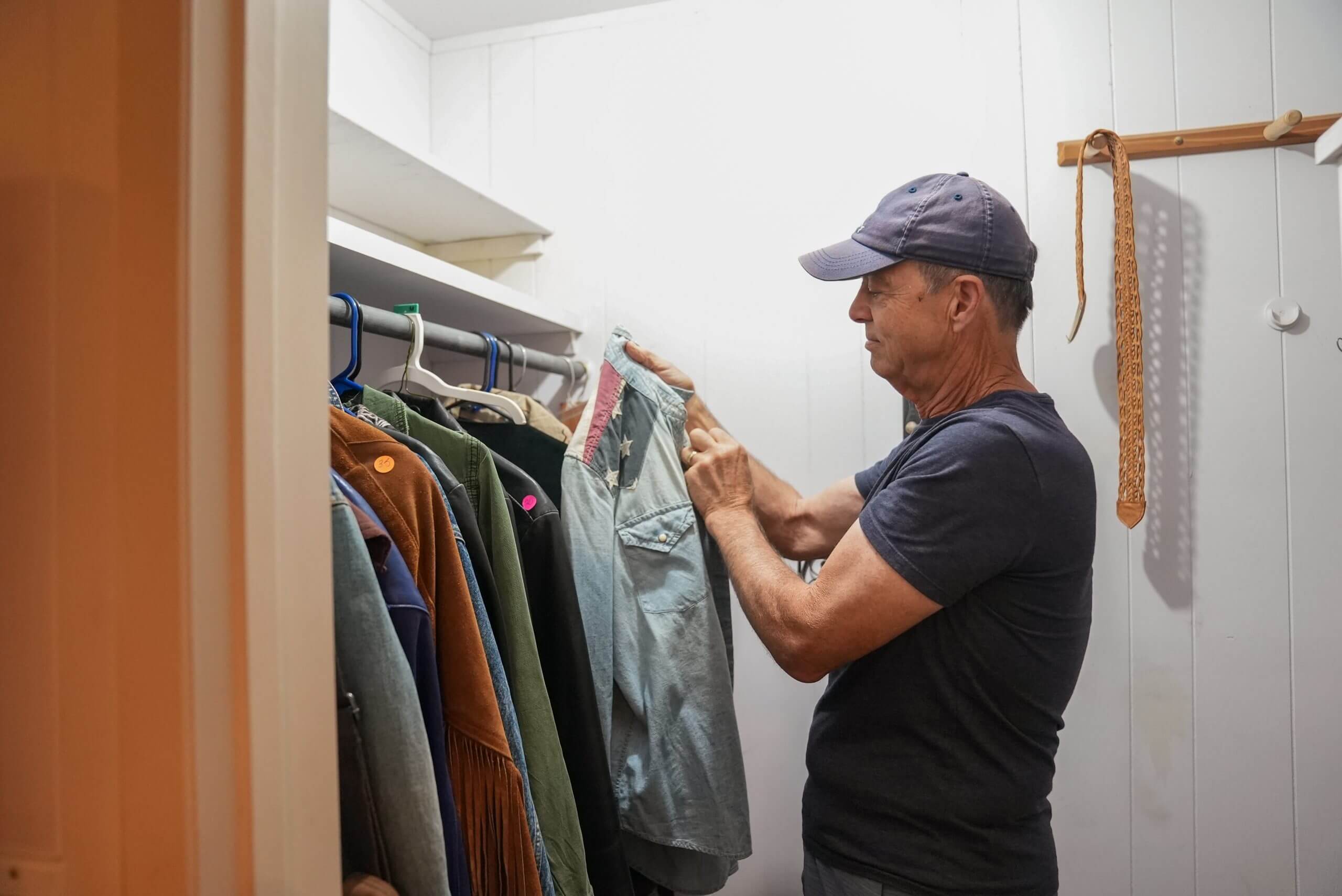 man searching for clothes in closet